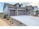 Stylish gray home showcasing a large driveway, two-car garage, and beautiful landscaping at 3991 Descent St, Castle Rock, CO 80108