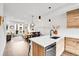 Stylish open concept kitchen with stainless steel appliances, wood accents, and a breakfast bar at 3458 W 63Rd Ave, Denver, CO 80221