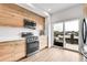 Stylish kitchen with stainless steel appliances, light wood cabinets, and a sliding door to a cozy outdoor patio at 3458 W 63Rd Ave, Denver, CO 80221