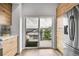 Chic kitchen with modern appliances and light wood cabinets, showcasing a sliding door to an outdoor patio at 3458 W 63Rd Ave, Denver, CO 80221