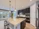 Modern kitchen features dark cabinetry, stainless steel appliances, and a large island with granite countertop at 10045 Copenhagen St, Parker, CO 80134
