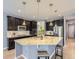 Modern kitchen features dark cabinetry, stainless steel appliances, and a large island with granite countertop at 10045 Copenhagen St, Parker, CO 80134