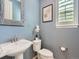 Powder room with pedestal sink, toilet and bright shuttered window at 10045 Copenhagen St, Parker, CO 80134