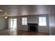Open living room with hardwood floors, a brick fireplace, and sliding glass doors at 19025 E Bethany Pl, Aurora, CO 80013