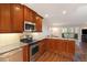 Well-lit kitchen with stainless steel appliances, granite countertops, and wood cabinets at 9315 E Center Ave # 3D, Denver, CO 80247