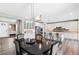 Open-concept kitchen featuring stainless steel appliances, white cabinets, a center island, and adjacent dining area at 7925 S Grand Baker St, Aurora, CO 80016