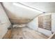 Unfinished attic space with wooden floors, white walls, and built in bench seating at 3241 Sheridan Blvd, Wheat Ridge, CO 80212