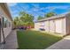 Landscaped backyard with artificial turf, outdoor seating area, and a Colorado flag at 3241 Sheridan Blvd, Wheat Ridge, CO 80212