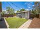 Charming backyard with artificial turf, fire pit seating, and a detached structure with a Colorado flag at 3241 Sheridan Blvd, Wheat Ridge, CO 80212