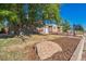 View of the home's exterior highlighting the yard, landscaping, and pink front door at 3241 Sheridan Blvd, Wheat Ridge, CO 80212