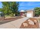 Charming brick home featuring a pink door, a well-manicured front yard, and a one-car garage at 3241 Sheridan Blvd, Wheat Ridge, CO 80212