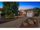 Brick home with a well-manicured lawn, featuring a pink door, covered porch, and a one car garage at 3241 Sheridan Blvd, Wheat Ridge, CO 80212
