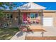 Inviting brick home with a cozy covered porch, a pink front door, and a meticulously maintained lawn at 3241 Sheridan Blvd, Wheat Ridge, CO 80212