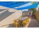 Outdoor patio area with a large dining table, yellow chairs, and blue sunshade covering the space at 3241 Sheridan Blvd, Wheat Ridge, CO 80212