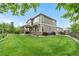 Expansive backyard featuring lush green grass, mature trees, and a covered patio with stone columns at 1920 Pioneer Cir, Lafayette, CO 80026