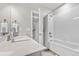Bright white bathroom features a shower-tub combination, white tile, and a sleek vanity with a white countertop at 1920 Pioneer Cir, Lafayette, CO 80026
