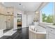 The primary bathroom boasts a soaking tub and a glass enclosed shower with black tiled flooring at 1920 Pioneer Cir, Lafayette, CO 80026