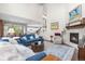 Cozy living room with a fireplace, plush seating, and an open view into the dining area and kitchen at 1920 Pioneer Cir, Lafayette, CO 80026