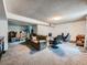 Finished basement with a sofa, and two gaming chairs plus carpeted floors at 14665 E Stanford Pl, Aurora, CO 80015