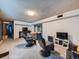 Finished basement with two gaming chairs plus carpeted floors and access to utilities at 14665 E Stanford Pl, Aurora, CO 80015
