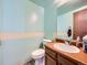 Cozy bathroom with linoleum floors, a wood vanity, and a toilet at 14665 E Stanford Pl, Aurora, CO 80015