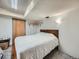 Basement bedroom featuring white walls, carpeted floor, small wooden shelves and door at 14665 E Stanford Pl, Aurora, CO 80015