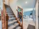 Open entryway featuring carpeted stairs and a view of the living room with light blue walls at 14665 E Stanford Pl, Aurora, CO 80015