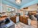 Spacious kitchen with wooden cabinets, sink, and a view into the dining room and fireplace at 14665 E Stanford Pl, Aurora, CO 80015
