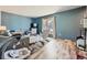 Comfortable living room with calming blue walls, wood floors, and a large bay window at 14665 E Stanford Pl, Aurora, CO 80015