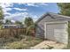 Detached garage with a white door and a gravel driveway at 1164 Chester St, Aurora, CO 80010