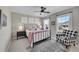 Bright bedroom with a queen bed, ceiling fan, and armchair at 14653 E Crestridge Dr, Centennial, CO 80015