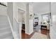 Bright entryway with staircase, powder room, and view of living room at 14653 E Crestridge Dr, Centennial, CO 80015