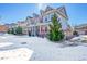 Two-story home with red front door, snow-covered yard, and evergreen trees at 14653 E Crestridge Dr, Centennial, CO 80015