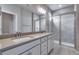 Bright bathroom features double vanity with quartz countertops and sleek, glass-enclosed shower at 16744 W 93Rd Pl, Arvada, CO 80007