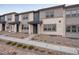 Exterior view of modern townhomes with stone facade and well manicured yard at 16744 W 93Rd Pl, Arvada, CO 80007