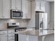 Charming kitchen showcases stainless steel appliances, gray countertops, and white cabinetry at 16744 W 93Rd Pl, Arvada, CO 80007