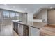 Open-concept kitchen featuring a center island with stone countertops, stainless steel appliances, and abundant natural light at 16744 W 93Rd Pl, Arvada, CO 80007