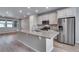 Open-concept kitchen featuring a center island with stone countertops, stainless steel appliances, and abundant natural light at 16744 W 93Rd Pl, Arvada, CO 80007