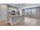 Open-concept kitchen featuring a center island with stone countertops, stainless steel appliances, and abundant natural light at 16744 W 93Rd Pl, Arvada, CO 80007