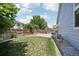 This spacious backyard features a well-manicured lawn, privacy fence, stone patio, and classic home siding at 13959 E 106Th Ave, Commerce City, CO 80022