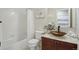 Cozy bathroom with vanity, tile backsplash, decorative sink, and shower-tub combo at 13959 E 106Th Ave, Commerce City, CO 80022