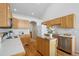 Bright kitchen featuring wooden floors and cabinets, stainless appliances, and a functional center island at 13959 E 106Th Ave, Commerce City, CO 80022