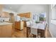 Open concept kitchen with wood cabinets, wood floors, a kitchen island, and a sliding door to the backyard at 13959 E 106Th Ave, Commerce City, CO 80022