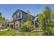 Inviting two-story home with mature trees, stone details, and lush greenery at 9545 Grand Cypress Cv, Lone Tree, CO 80124