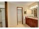 Clean bathroom with granite countertop, wooden cabinets, and a large mirror at 722 S Eagle St, Aurora, CO 80012