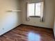 Simple bedroom with wood-look flooring and a window with curtains at 722 S Eagle St, Aurora, CO 80012