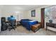 Well-lit bedroom with a desk setup, plush carpeting, and a window letting in natural light at 12125 Bannock St # C, Westminster, CO 80234