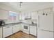 Well-lit kitchen featuring white cabinets, appliances, and granite countertops at 12125 Bannock St # C, Westminster, CO 80234