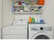 Efficient laundry room with washer, dryer, and storage shelves for cleaning supplies at 12125 Bannock St # C, Westminster, CO 80234