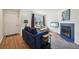 Cozy living room features a blue fireplace, TV, couches, and hardwood floors at 12125 Bannock St # C, Westminster, CO 80234